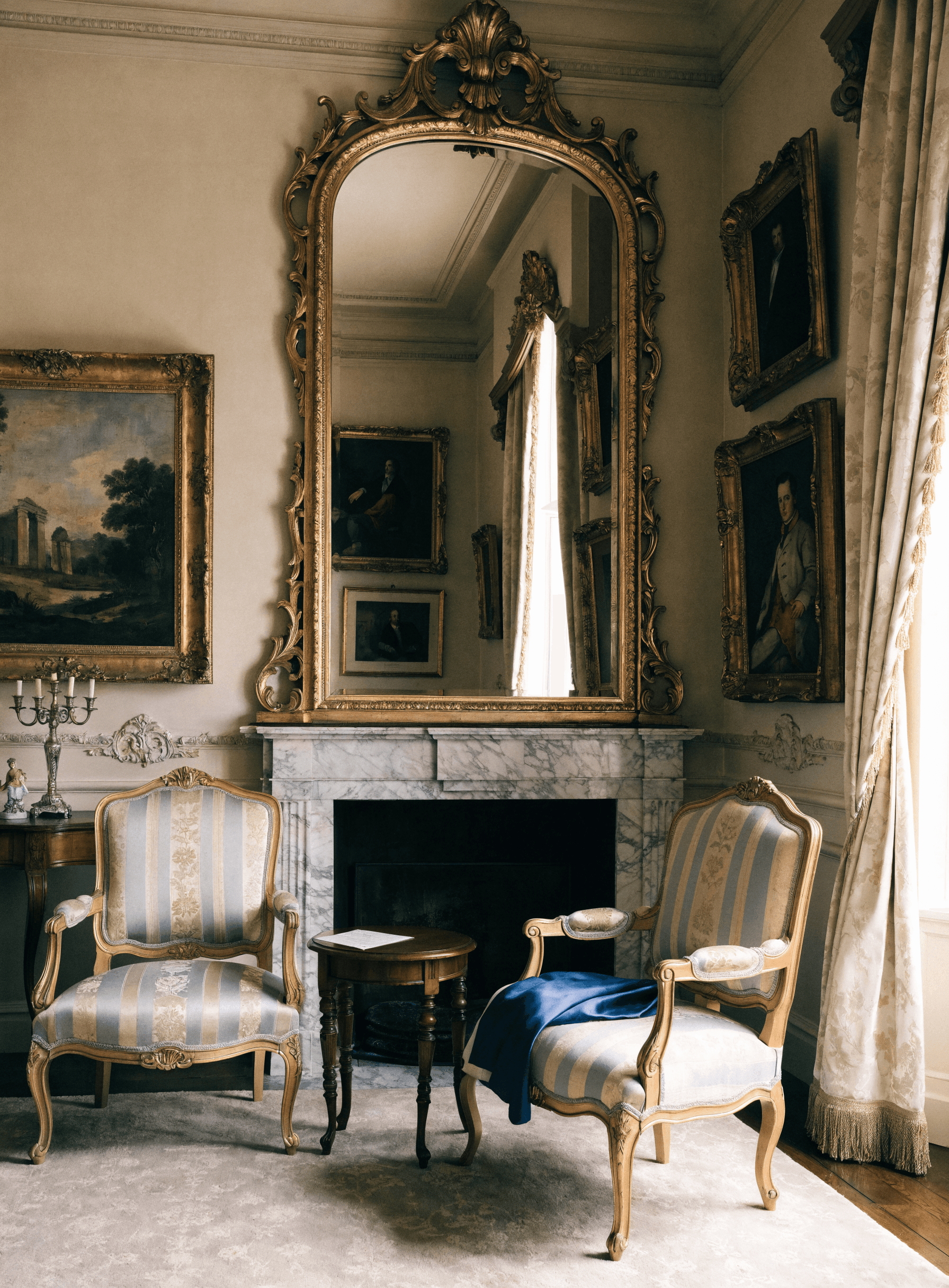 Salon recomposé — fauteuils Louis XVI, miroir doré et tableaux anciens